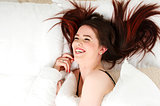 Woman laid in bed laughing