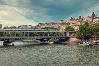 Train passing on famous Pont de Bir-Hakeim bridge across Seine River in Paris, France (toned).