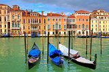Gondolas on Grand Canal in front of old colorful houses in Venice, Italy.