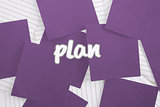 Plan against purple paper strewn over notepad