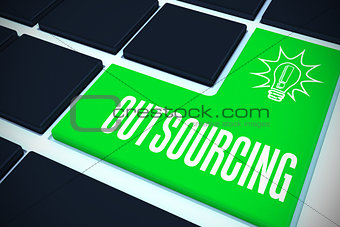 Outsourcing on black keyboard with green key