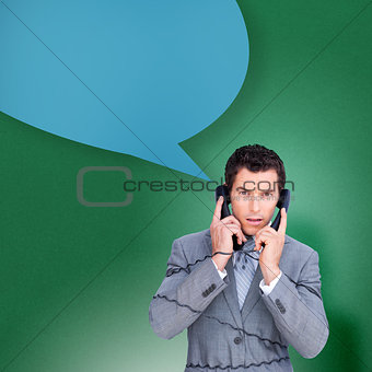 Composite image of angry businessman tangled up in phone wires with speech bubble
