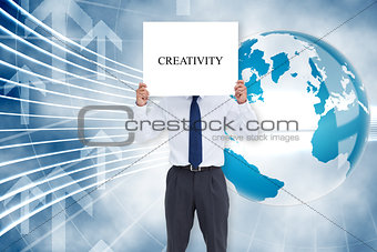 Businessman holding card saying creativity