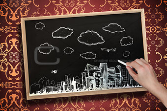 Composite image of hand drawing cityscape with chalk