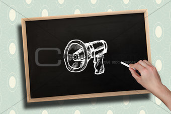 Composite image of hand drawing megaphone with chalk