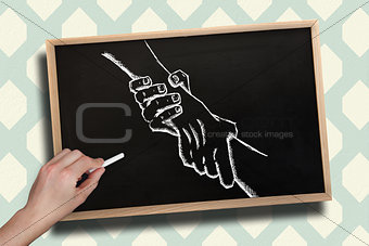 Composite image of hand drawing handshake with chalk