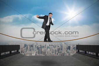 Composite image of mature businessman doing a balancing act