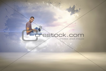 Composite image of man wearing glasses sitting using laptop and looking at camera