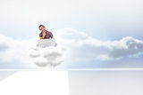 Composite image of thinking man sitting on cloud  using laptop and smiling