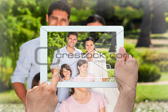 Composite image of hand holding tablet pc