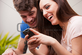 man and woman having fun with their mobile phones