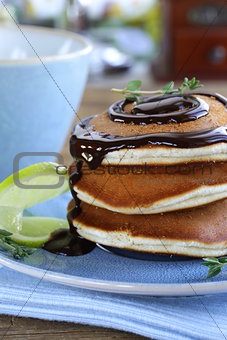 homemade pancakes with chocolate syrup and thyme