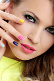 Beautiful girl touch her face with colored fingers