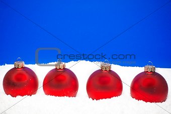 four christmas balls on the snow
