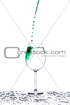 Glass with flowing stream of green water