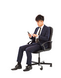 young businessman touching smart phone on chair