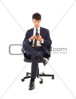 asian businessman touching smart phone on chair