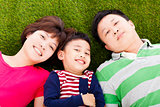 happy parents and son lying on a meadow