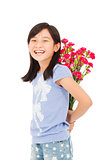 Smiling girl hiding a bouquet of carnations