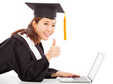 female graduation using a laptop and thumb up 