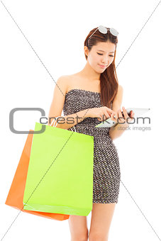  young  woman holding shopping bags and using  the tablet