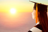 female graduation is thinking future with sunset background