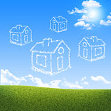 Houses of clouds in the sky over green grass