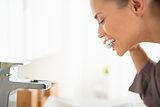 Young woman brushing teeth