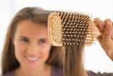 Closeup on happy young woman combing hair
