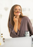 Happy young woman making mustache with hair