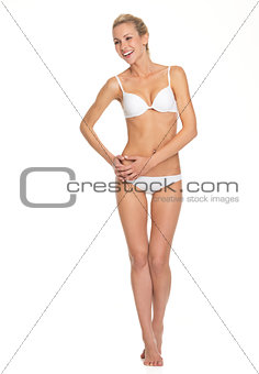 Full length portrait of smiling young woman in lingerie looking 