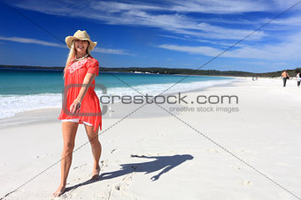 Happy woman walking along beautiful beach