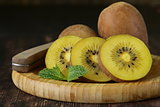 ripe yellow kiwi on a wooden board