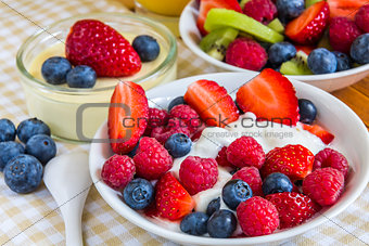 sweet berries in small bowls with orange juice