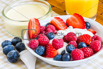 sweet raw berries with orange juice on coverlet