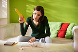 female student doing homeworks with big pencil