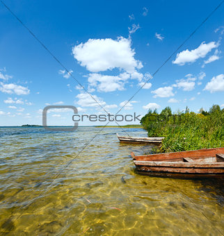 Summer lake view with wooden boats.