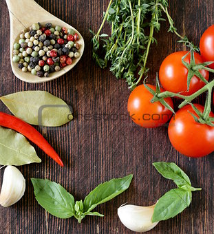 Spices, herbs and vegetables on a wooden background