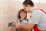Boy assisting his father installing electical outlets