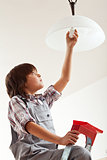Boy changing lightbulb