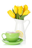 Yellow tulips and tea cup with lemon slice