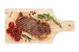 Sirloin steak with rosemary and cherry tomatoes on a cutting boa