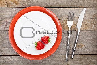 Plate with ripe strawberry and silverware
