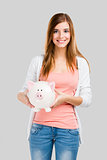 Blonde woman with a piggy bank