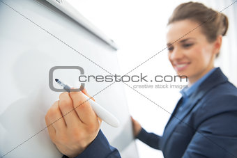Closeup on business woman writing in flipchart