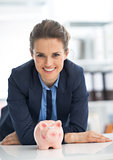 Portrait of smiling business woman with piggy bank