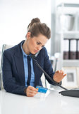Business woman with credit card dialing phone