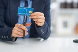 Closeup on business woman cutting credit card with scissors
