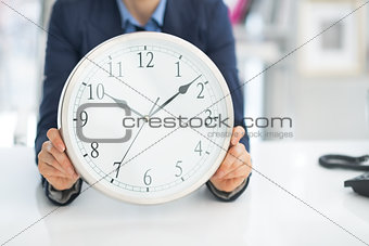Closeup on business woman holding clock