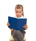 little girl sitting on a chair and reading blue book